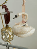 Decorative swan ornament with ribbons on a light gray background
