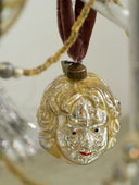 Decorative pendant with a face design on a blurred background