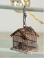 Decorative birdhouse ornament hanging on a metal rod with a blurred background