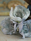Handmade and hand-dyed crepe paper flowers in solid colors. Bouquets of paper flower Christmas ornaments in blue, white, and pale pink